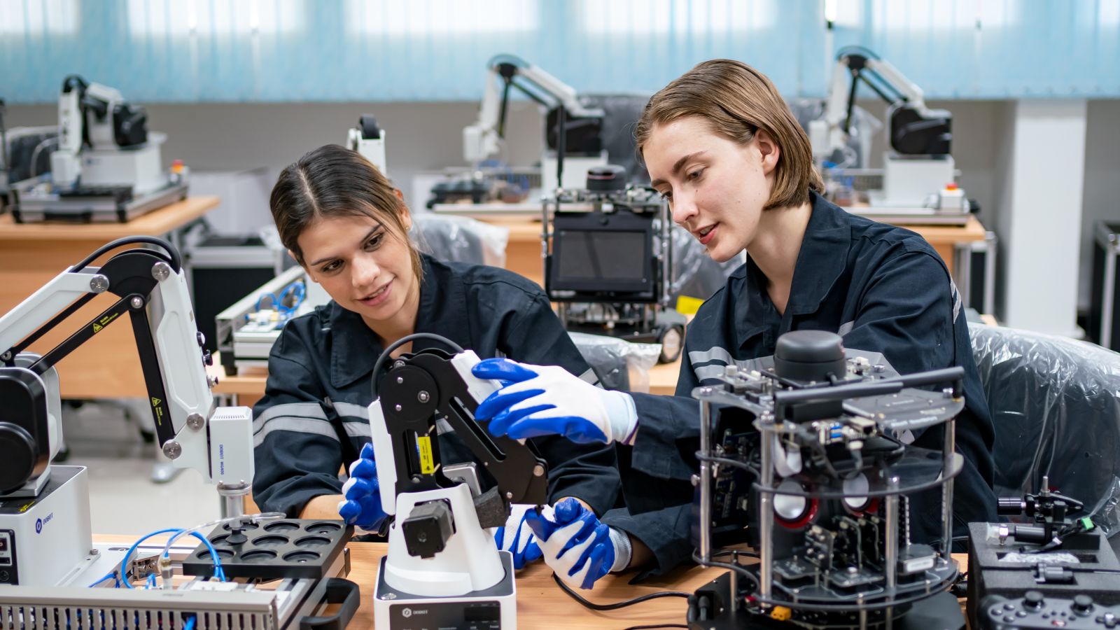 Fabrikarbeiterinnen arbeiten an Roboter